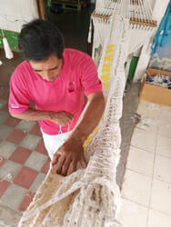 Travail manuel de finition d'un hamac en coton dans un atelier au Nicaragua