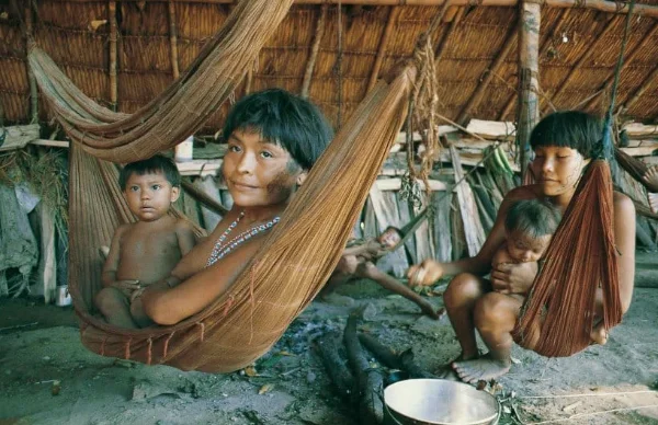 Famille indigène balançant son bébé dans un hamac