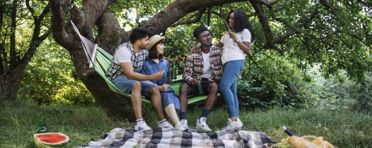 Hamac pour discuter groupe d'amis discutant dans un hamac dans un champ vert